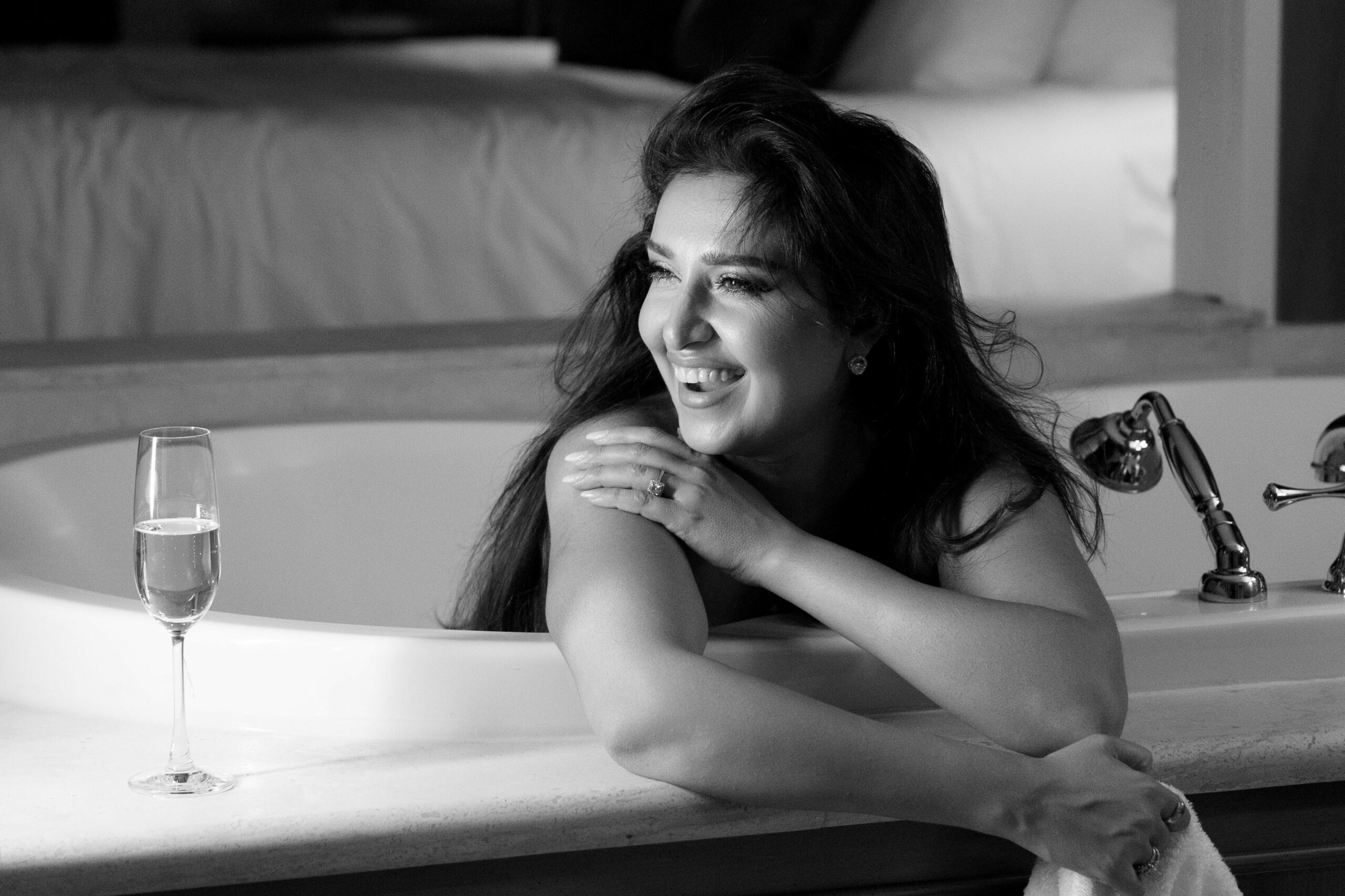 Black and white candid portrait of Mozhdah Jamalzadah laughing in her hotel room.