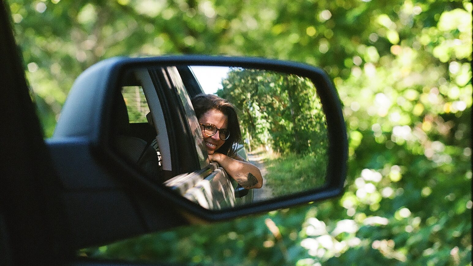 photo of a woman through a rear mirror