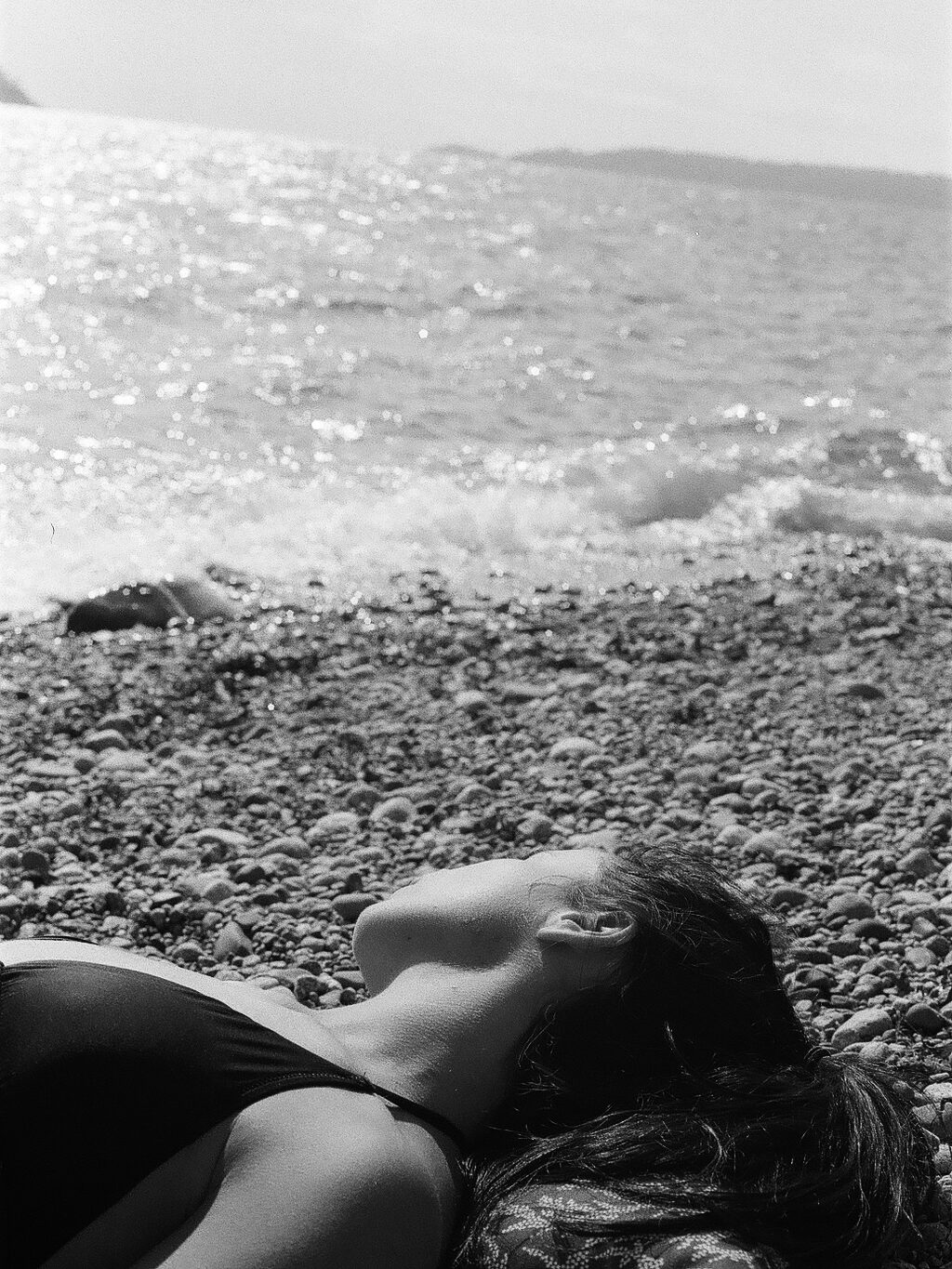 Film photography in Black and white. A woman i laying on the beach