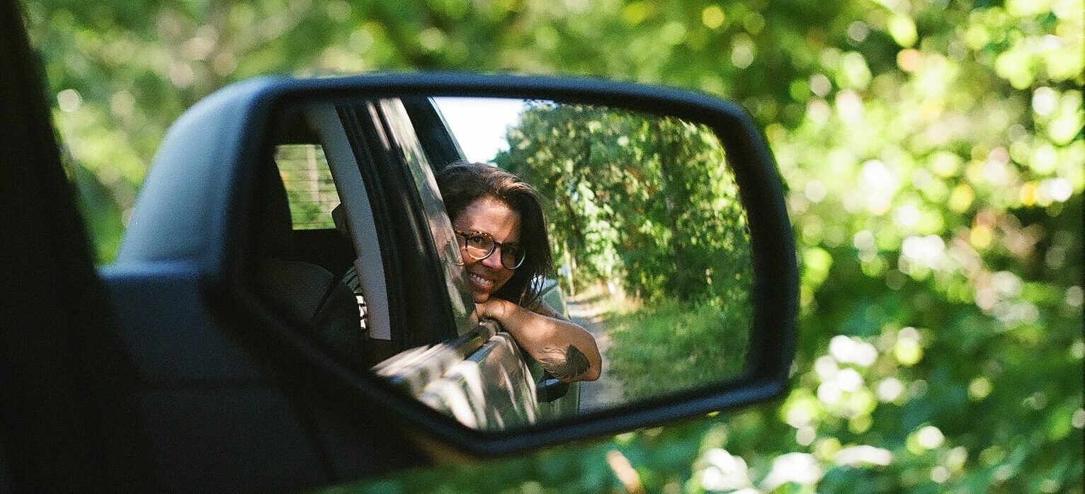 photo of a woman through a rear mirror